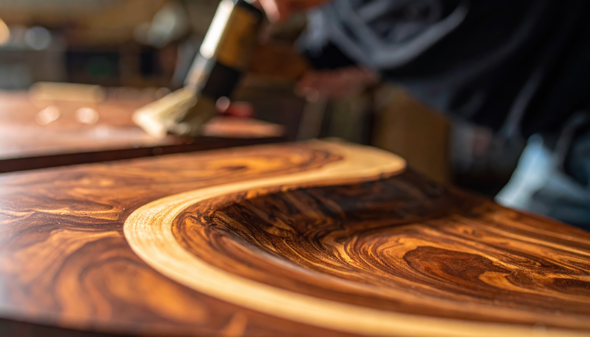 Craftsman brushing varnish onto figured timber